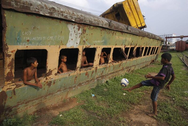 Bangladeshi children play with a football at a railway track in Dhaka last year. Andrew Biraj / Reuters / May 29, 2014