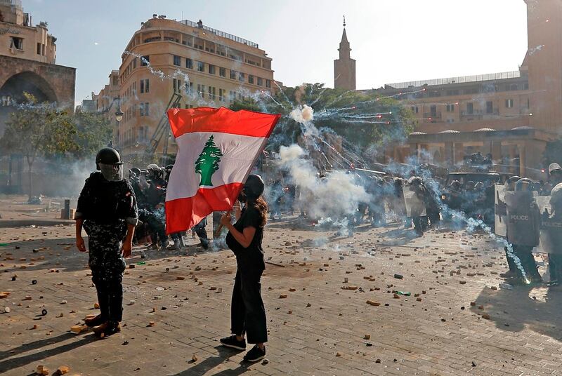 A Lebanese protester waves the national flag during clashes with security forces in downtown Beirut. AFP