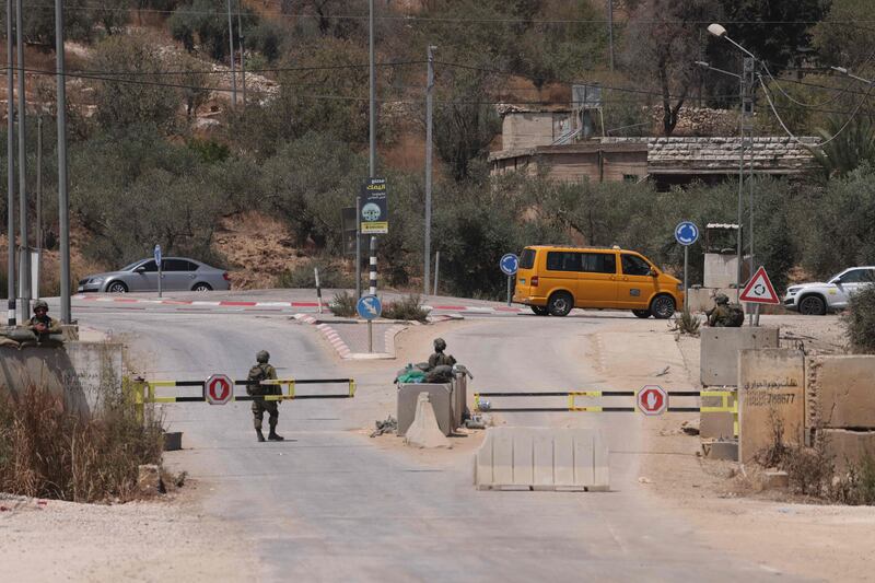 Israeli security forces block a road in Beita during a search for the suspected perpetrator of an attack which killed two Israelis. AFP