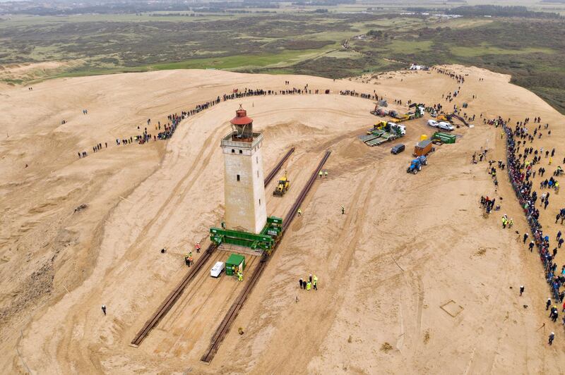 Spectators watch the Rubjerg Knude Lighthouse being moved on rails in Jutland, Denmark. EPA