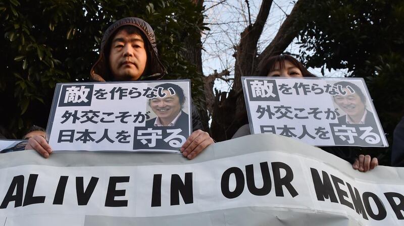 People stage a silent rally for Kenji Goto , the Japanese hostage purportedly killed by ISIL, near the prime minister's official residence in Tokyo on February 1, 2015. Some 200 people gathered the rally with billboards that said: "Kenji, you will be alive in our memories." Kazuhiro Nogi/AFP Photo
