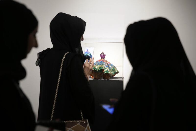 Visitors take a look at ‘Thehban’, a custom-designed miniature mannequin, at the gallery in Abu Dhabi.