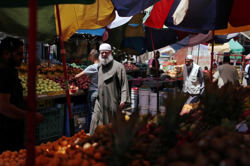 Palestinian shoppers walk in a market in Khan Younis refugee camp in the southern Gaza Strip.  Reuters