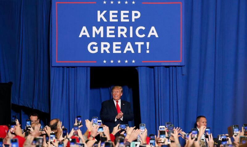 President Donald Trump pauses under the Keep America Great banner before speaking on a number of topics including the successes of his administration and making fun of his critics a rally in Tupelo, Miss. days before the Nov. 5 general elections in Mississippi. AP
