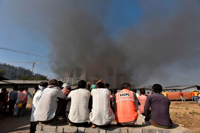 People watch as smoke rises after a fire broke out at India's Serum Institute in Pune. AFP