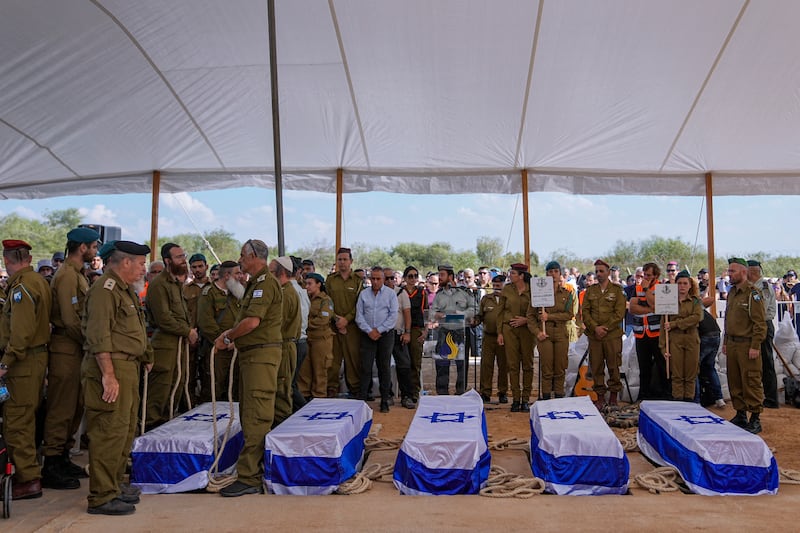 Mourners gather around the five coffins of the Kotz family during their funeral in Gan Yavne. AP