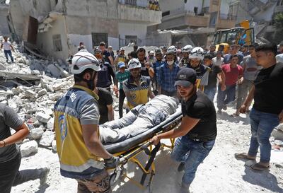 Members of the Syrian Civil Defence (White Helmets) carry the body of a victim at the site of a reported air strike on the town of Ariha, in the south of Syria's Idlib province on July 27, 2019. Regime airstrikes on July 27 killed 10 civilians in northwest Syria, where ramped up attacks by Damascus and its ally Russia have claimed the lives of hundreds since late April. Idlib and parts of the neighbouring provinces of Aleppo, Hama and Latakia are under the control of Hayat Tahrir al-Sham, a jihadist group led by Syria's former Al-Qaeda affiliate. 
 / AFP / Omar HAJ KADOUR
