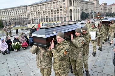 Ukrainian servicemen carry the coffins with the bodies of Ukrainian servicemen Oleg Khomyuk, 52, and his 25-year-old son Mykyta, killed in combat in Bakhmut, during a funeral ceremony at Independence Square in Kyiv on March 10, 2023, amid the Russian invasion of Ukraine.  - Mourners gathered in the centre of Kyiv on March 10, 2023, to pay their respects to a father and son killed together in the fierce fighting for Ukraine's eastern city of Bakhmut, a town that has become a symbolic prize in Russia's war on Ukraine and the scene of months of heavy combat.  (Photo by Sergei SUPINSKY  /  AFP)