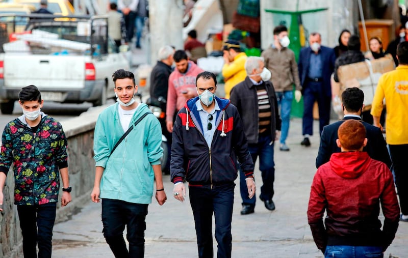 People, some wearing protective face masks, walk past shops along outside the Tajrish Bazaar in Iran's capital Tehran. Iran said on March 12 that it had asked the IMF for its first loan in decades to combat the COVID-19 coronavirus disease outbreak that has claimed 429 lives and infected more than 10,000 people. AFP