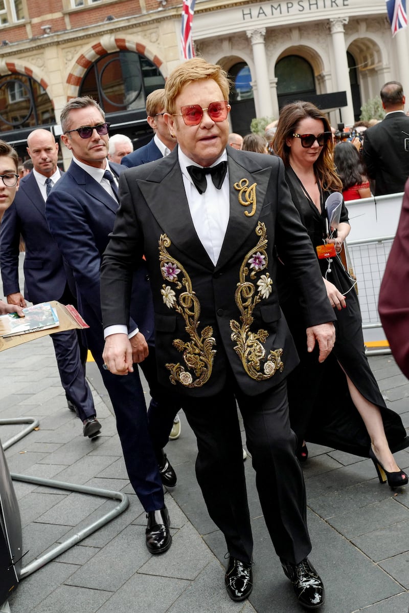 Elton John, wearing a black suit with gold initialled embellishment, attends the European premiere of 'The Lion King' at Odeon Luxe Leicester Square on July 14, 2019. Getty Images