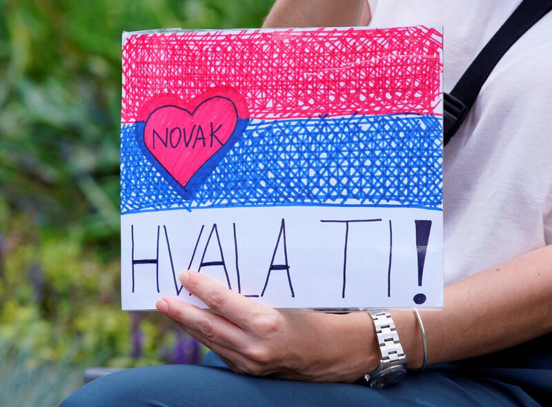 A supporter of Serbian tennis player Novak Djokovic holds a sign outside the Park Hotel. Reuters