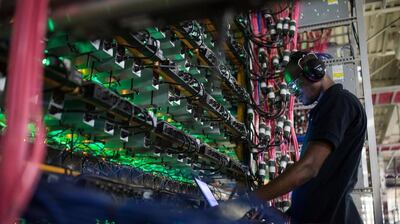 A technician monitors cryptocurrency mining rigs at a facility in Quebec, Canada. Bloomberg