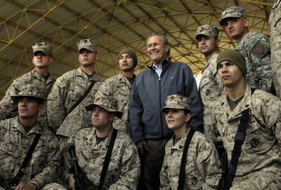 (FILES) In this file photo taken on December 09, 2006 a Photo released by the US Departmet of Defence shows outgoing US Secretary of Defence Donald Rumsfeld posing with troops assigned to Al-Asad Air Base in Iraq's restive Al-Anbar province during a surprise visit to Iraq, 09 December 2006.  - Former US defense secretary Donald Rumsfeld, who led the nation into war in Afghanistan and Iraq during the presidency of George W Bush, has died at the age of 88 in New Mexico, his family announced June 30, 2021.  (Photo by Cherie A Thurlby  /  DoD  /  AFP)