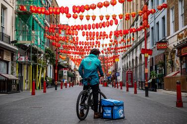 A food delivery courier waits for orders in Chinatown in London. The food-delivery startup sank more than 30 per cent in its London debut after its initial public offering raised £1.5bn. Bloomberg