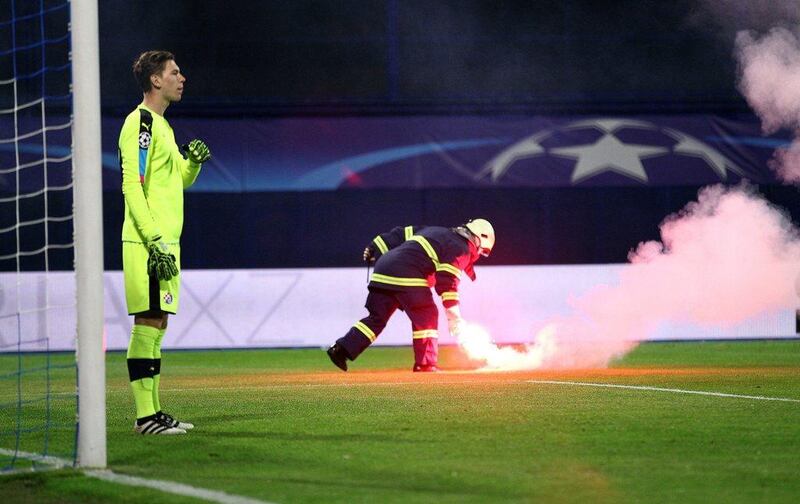 A firefighter removes a flare during the match between Juventus and Dinamo Zagreb. Antonio Bronic / Reuters