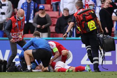 (FILES) In this file photograph taken on June 12, 2021, Denmark's midfielder Christian Eriksen (bottom C) receives medical attention after collapsing on the pitch during the UEFA EURO 2020 Group B football match between Denmark and Finland at the Parken Stadium in Copenhagen.  (Photo by Friedemann Vogel  /  various sources  /  AFP)