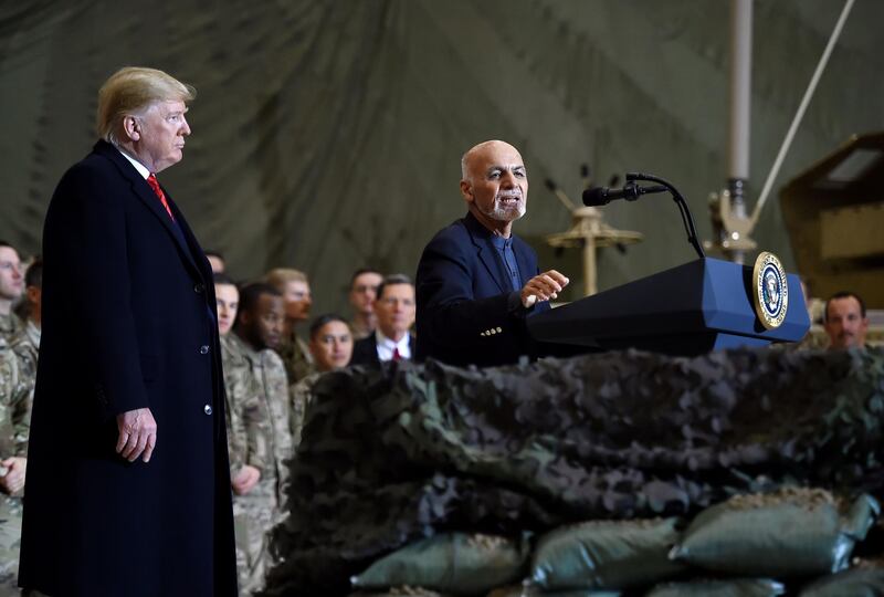Afghan's President  Ashraf Ghani  speaks to US soldiers as US President Donald Trump listens  during a surprise Thanksgiving day visit at Bagram Air Field, on November 28, 2019 in Afghanistan. / AFP / Olivier Douliery
