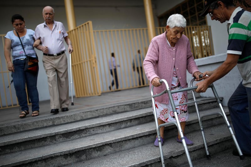 Elderly Venezuelan citizens depart after casting their votes at a polling station during the presidential election in Caracas, Venezuela. Carlos Garcia Rawlins / Reuters