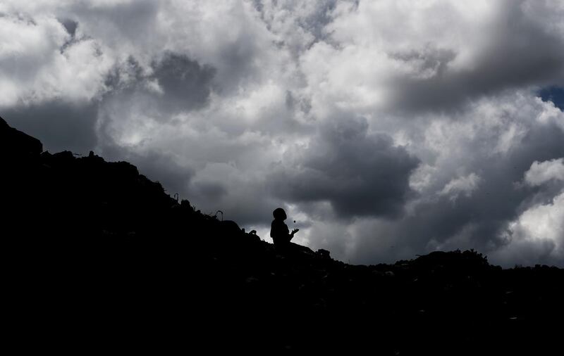 A young boy sits on top of a mountain of garbage at the dump in the Dandora slum of Nairobi, Kenya. AP Photo