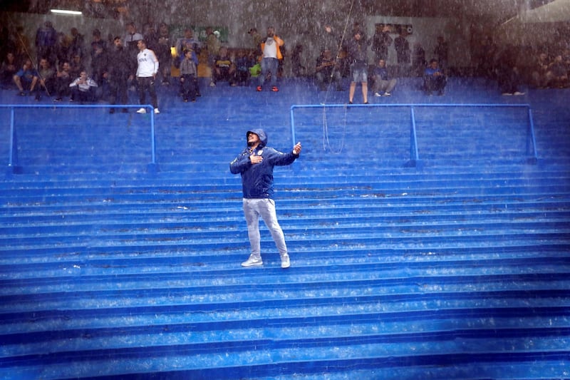 A Boca Juniors fan sings in the rain. EPA