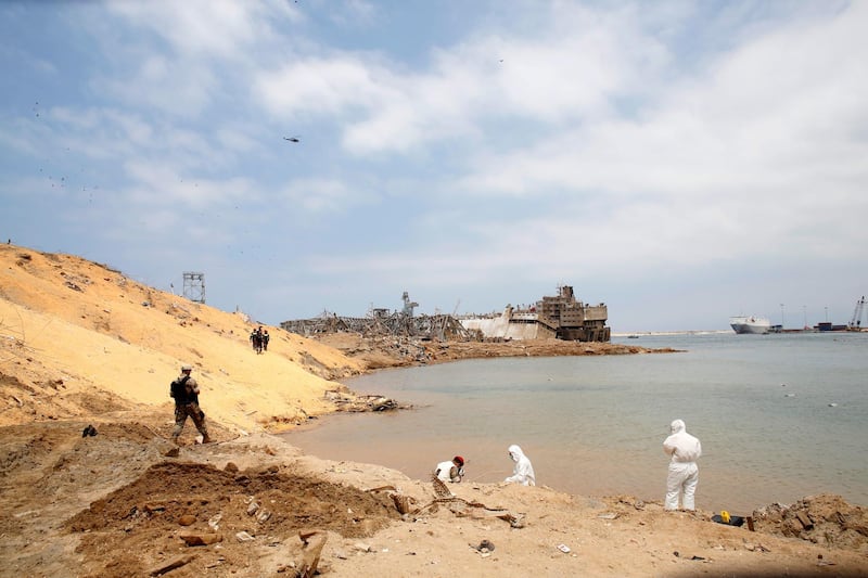 Workers are pictured at the devastated site of the explosion at the port of Beirut.  EPA