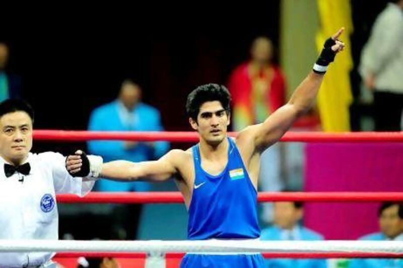 Vijender Singh of India salutes after beating Abbos Atoev of Uzbekistan during the men's 75kg boxing final competition against Zhang Jiawei of China at the 16th Asian Games in Guangzhou on November 26, 2010. AFP PHOTO