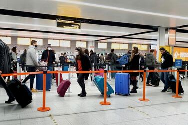 Passengers queue for check-in at Gatwick Airport where new arrivals will be forced to provided a negative Covid-19 test. AP.