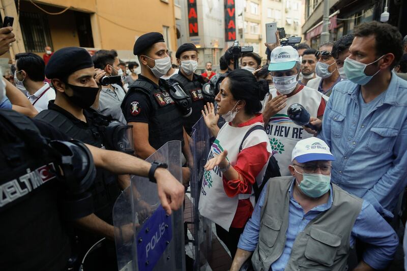Turkish police officers, wearing masks to protect from the spread of coronavirus, block supporters of pro-Kurdish People's Democratic Party (HDP), as they try to gather for a rally in Istanbul. AP Photo