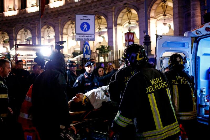 First responders evacuate a wounded person from Piazza della Repubblica in central Rome on October 23, 2018 after around 20 people were injured when an escalator leading to the Repubblica metro station collapsed in an accident believed to have been caused by Russian football fans.  / AFP / Cecilia FABIANO
