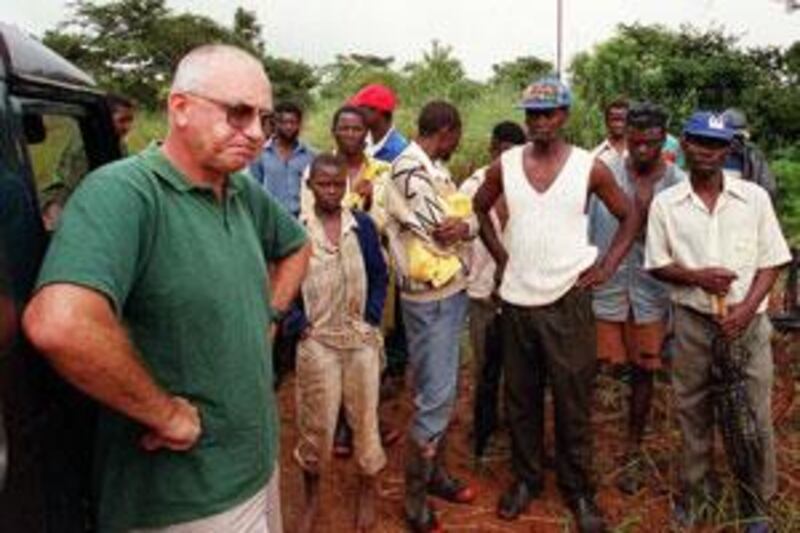 Zimbabwean farmer Andreo Malus, left, is pictured in 2000 on his property north of Harare at the start of Robert Mugabe's land grab scheme.