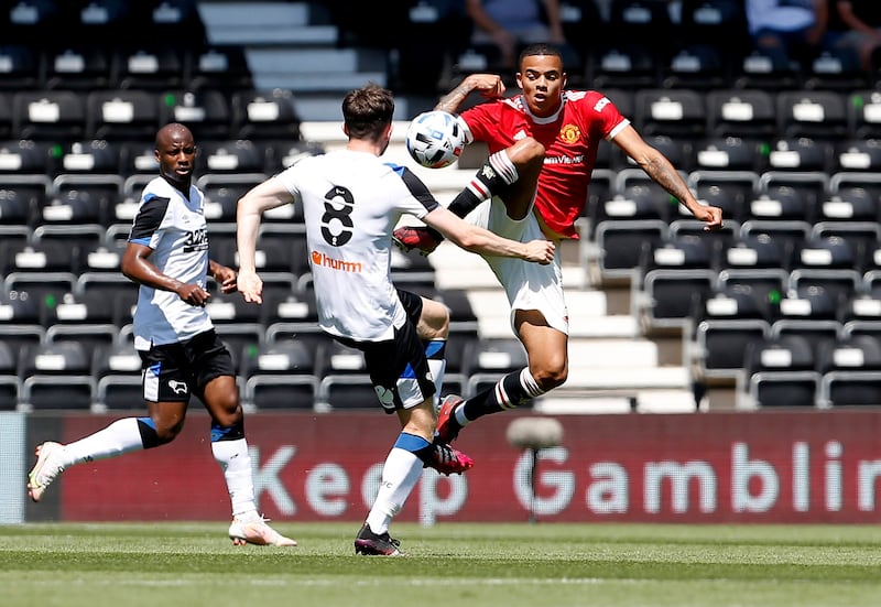 Manchester United's Mason Greenwood and Max Bird of Derby challenge for the ball.