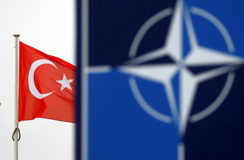 FILE PHOTO: A Turkish flag flies next to NATO logo at the Alliance headquarters in Brussels, Belgium, November 26, 2019.  REUTERS/Francois Lenoir/File Photo