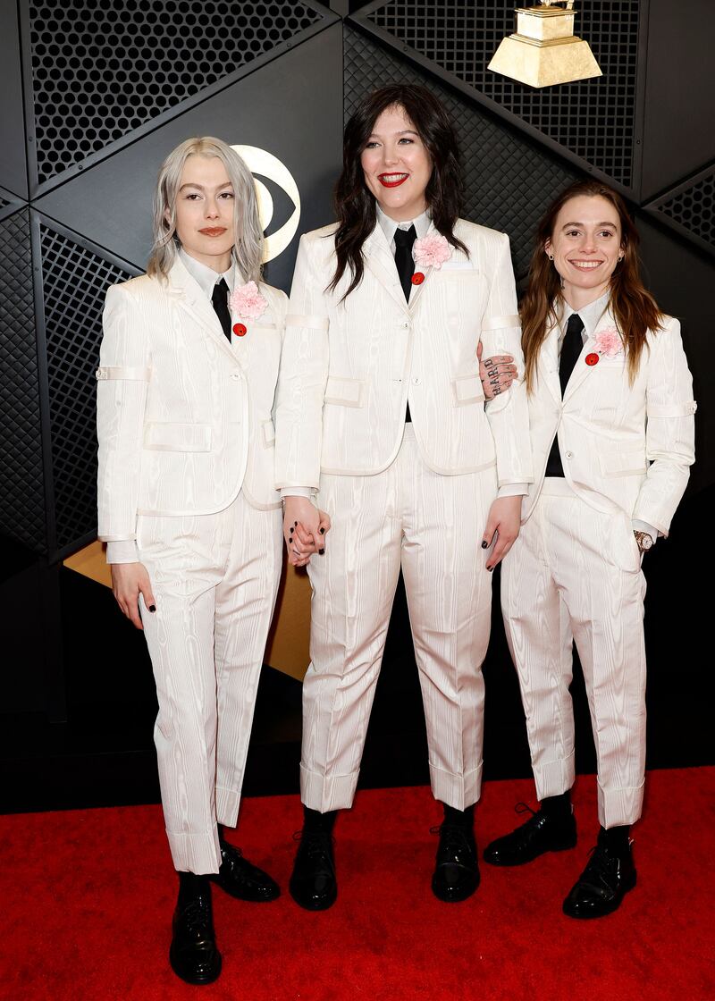 Phoebe Bridgers, Lucy Dacus and Julien Baker of Boygenius wear matching Thom Browne suits with red Artists For Ceasefire pins. Getty Images