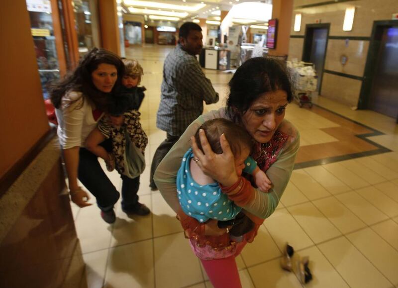 Women carrying children run for safety as armed police hunt gunmen who went on a shooting spree in Nairobi’s Westgate shopping centre. Goran Tomasevic / Reuters



