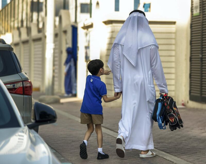 Abu Dhabi, U.A.E., September 2, 2018. 
 Pupils heading to school for the first day after the summer break at the Pearl Academy School on Muroor Road.-- a father walks his son to school.
Contact: Victor Besa / The National
Section:  NA
Reporter:  Anam Rizvi