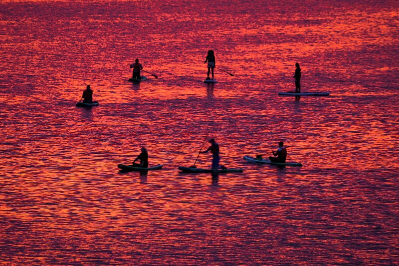 People steer their stand-up paddle-boards at sunset on the Velikaya River in Pskov, 300 kilometres south-west of St Petersburg, Russia. AP Photo