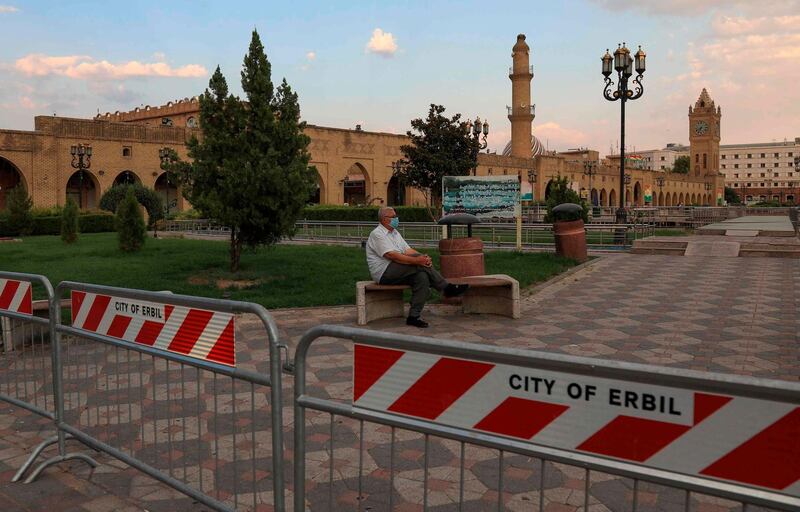 A man, wearing a protective mask, sits in the vicinity of Arbil Citadel in the capital of the northern Iraqi Kurdish autonomous region amid a lockdown to combat the spread of the coronavirus.  AFP