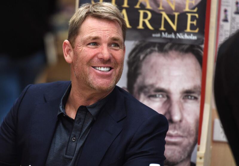 Australian cricketing great Shane Warne chats with a customer during a book signing event for his new autobiography titled "No Spin", in Melbourne on October 19, 2018.  Warne, Test cricket's second-most prolific wicket-taker with 708 scalps, in his new book has endorsed one of the most controversial figures in cricketing history, while also renewing his decades-old feud with former captain Steve Waugh. / AFP / William WEST
