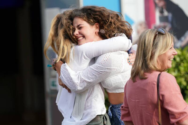 Millie Clark hugs a friend after receiving her A-level results at Norwich School in England. PA