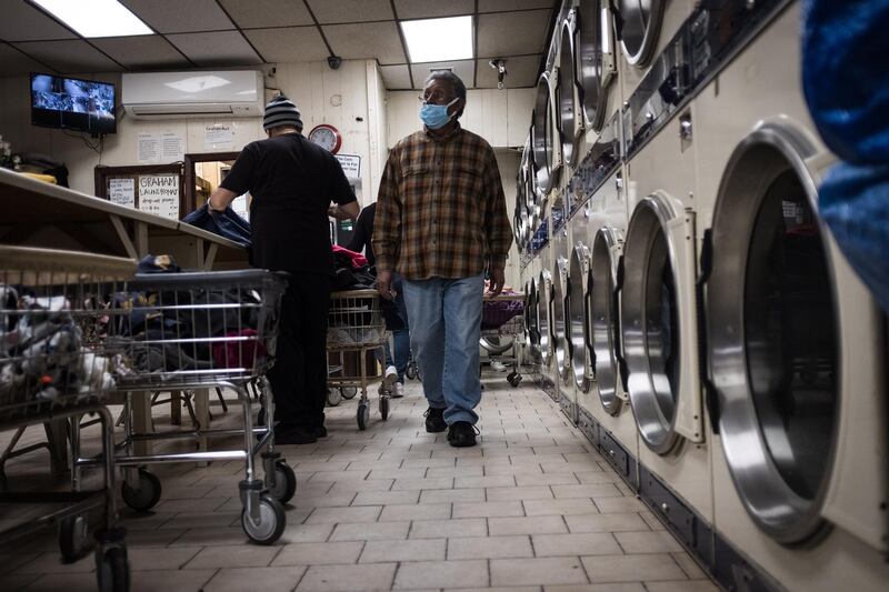 epa08402884 Ismael Taveras works in the "Graham Laundromat", the family run business he works at in Brooklyn, New York, USA, 23 April 2020 (issued 05 May 2020). Employees of gas stations, supermarkets, laundries, home delivery services or mechanics, the Latino community occupies many of the key positions that allow the United States to continue operating during the worst of the pandemic. Ismael Taveras, his brother Julio and his sister-in-law Nancy Cruz, run a neighborhood laundromat in East Williamsburg, Brooklyn. The three immigrants from the Dominican Republic became infected with the coronavirus and had to be quarantined for two weeks. After recovering, they reopened their laundry, a service they consider essential to their local community. Business has halved since the outbreak, as they had to introduce new business hours in order to properly disinfect the washing and drying machines.  EPA/Alba Vigaray  ATTENTION: This Image is part of a PHOTO SET