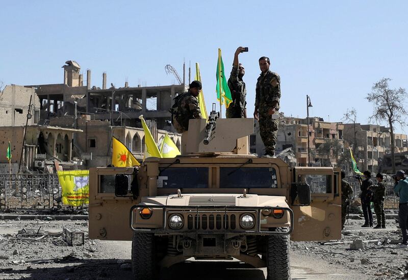 A Fighter of Syrian Democratic Forces takes a selfie as he stands on a military vehicle in Raqqa on October 17, 2017. Rodi Said / Reuters