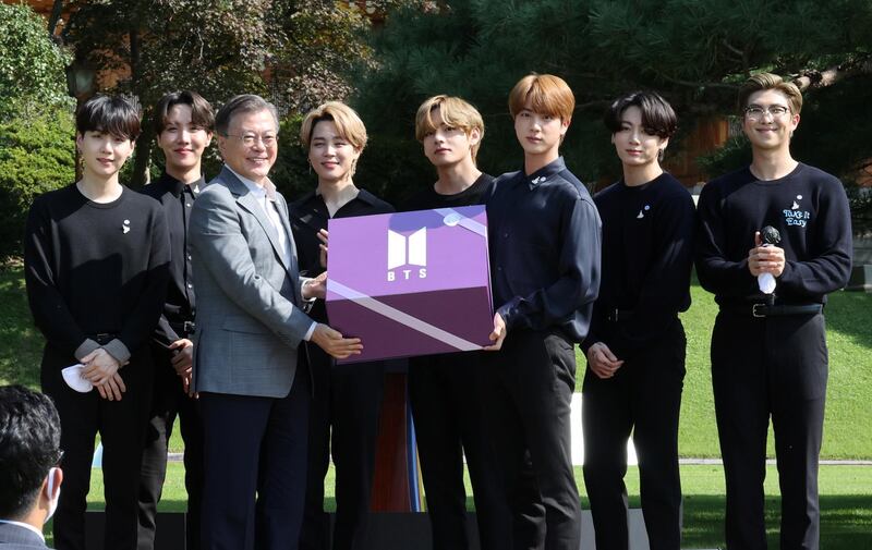 South Korean President Moon Jae-in and members of K-Pop boyband BTS pose for photographs with a gift given by BTS during Youth Day at the Presidential Blue House in Seoul, South Korea, September 19, 2020. Yonhap via Reuters