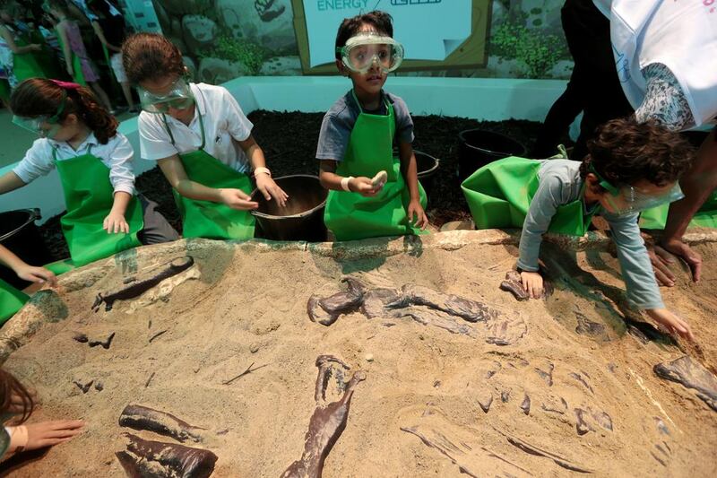 Youngsters get a hands-on experience of science as they take part in the ‘dig a dinosaur’ activity during the opening day of the Abu Dhabi Science Festival at Mushrif Central Park. The festival runs until November 22. Christopher Pike / The National