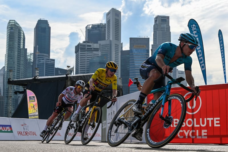 Danish rider Jonas Vingegaard, centre, and British riders Chris Froome, right, and Mark Cavendish, left, race around a corner during the first Tour de France Singapore Criterium race in Singapore. AFP