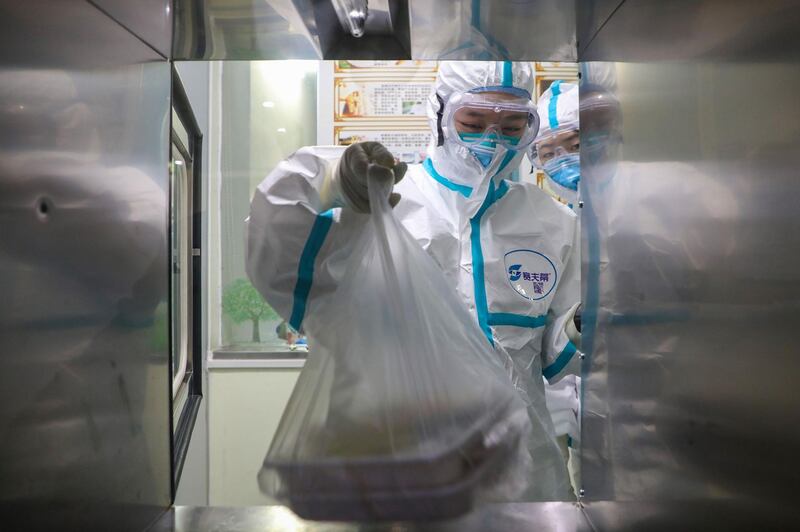 A medical staff member getting lunch boxes for patients through a window in an isolation ward at a hospital in Wuhan in China's central Hubei province, during the virus outbreak in the city. The World Health Organization declared a global emergency over the new coronavirus, as China reported January 31 the death toll had climbed to 213 with nearly 10,000 infections. AFP