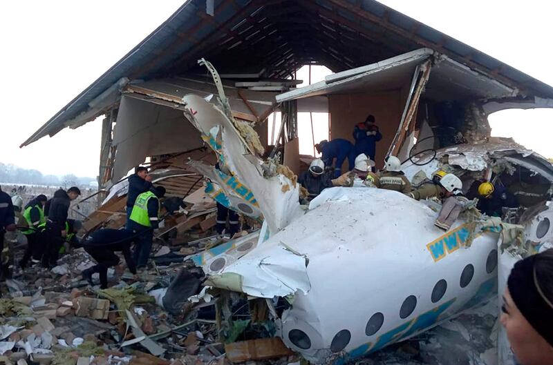 In this handout photo provided by the Emergency Situations Ministry of the Republic of Kazakhstan, police and rescuers work on the site of a plane crash near Almaty International Airport. AP