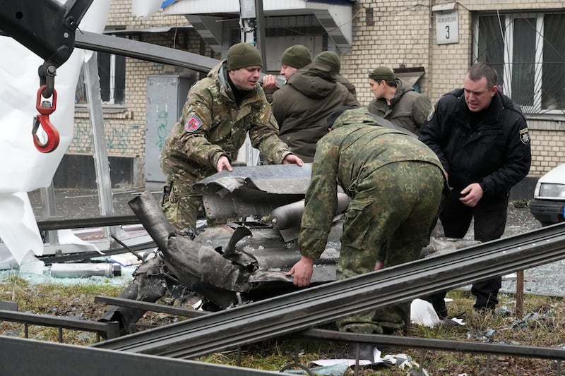 Workers load the debris of a rocket on to a lorry in the aftermath of Russian shelling in Kiev. AP