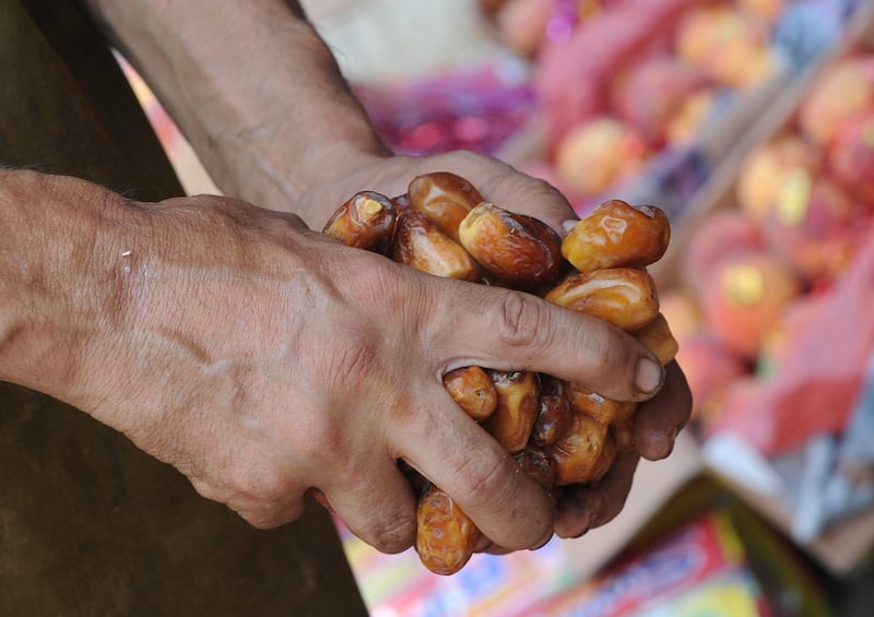 A Pakistani vendor arranges dates at his stall at a fruit market ahead of the Islamic holy month of Ramadan in Islamabad on July 8, 2013. Islam's holy month of Ramadan is celebrated by Muslims worldwide marked by fasting, abstaining from foods, sex and smoking from dawn to dusk for soul cleansing and strengthening the spiritual bond between them and the Almighty. AFP PHOTO / AAMIR QURESHI
 *** Local Caption ***  513227-01-08.jpg
