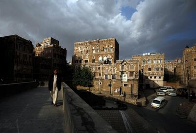 epa09131519 A Yemeni walks through a pedestrian bridge in front of historic buildings in the old city of Sana'a, Yemen, 12 April 2021. US envoy for Yemen Tim Lenderking, UN envoy for Yemen Martin Griffiths and other international representatives are meeting in Germany to reinvigorate diplomatic efforts which aim to secure a nationwide ceasefire between the warring factions in Yemen, the Houthis and the Saudi-backed government, in a fresh attempt to end six years of war, as the Houthis continues to intensify their attacks on the oil-rich Yemeni city of Marib and their cross-border missile and drone attacks on Saudi Arabia.  EPA/YAHYA ARHAB