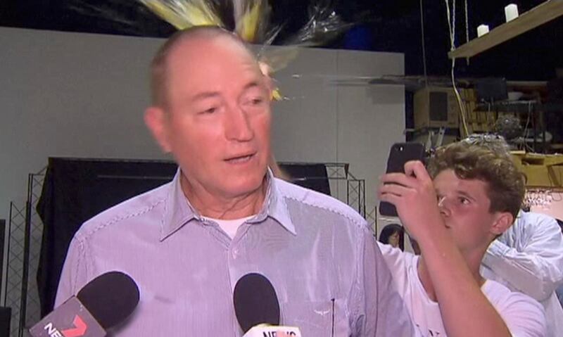 FILE - In this March 16, 2019, file image made from video, a teenager breaks an egg on the head of Senator Fraser Anning while he holds a press conference, in Melbourne. Police say they will not charge the Australian teenager or a senator for a spat in which the boy cracked an egg on the politicianâ€™s head and the man retaliated. (AP Photo/File)